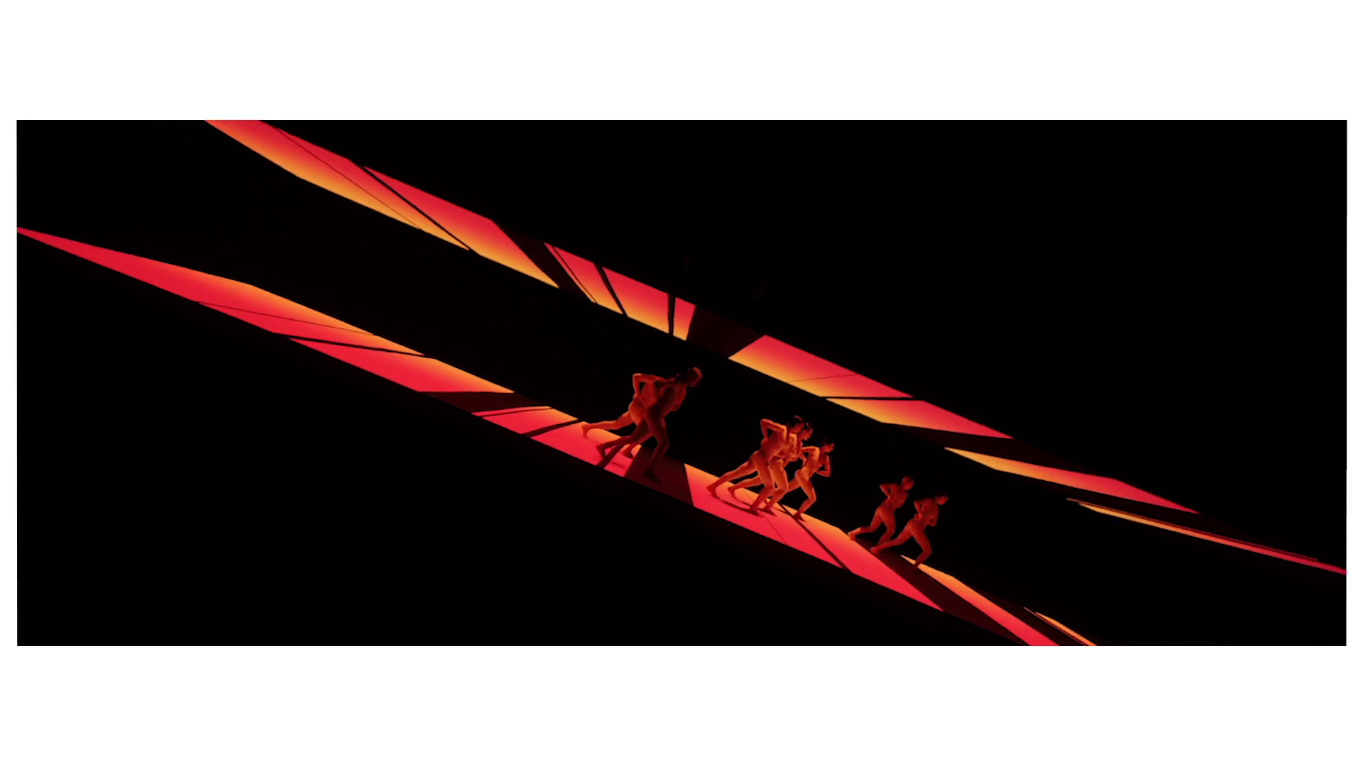 Dancers crossing a backdrop of red and orange op-art shards in the Dior Spring/Summer 2022 campaign film