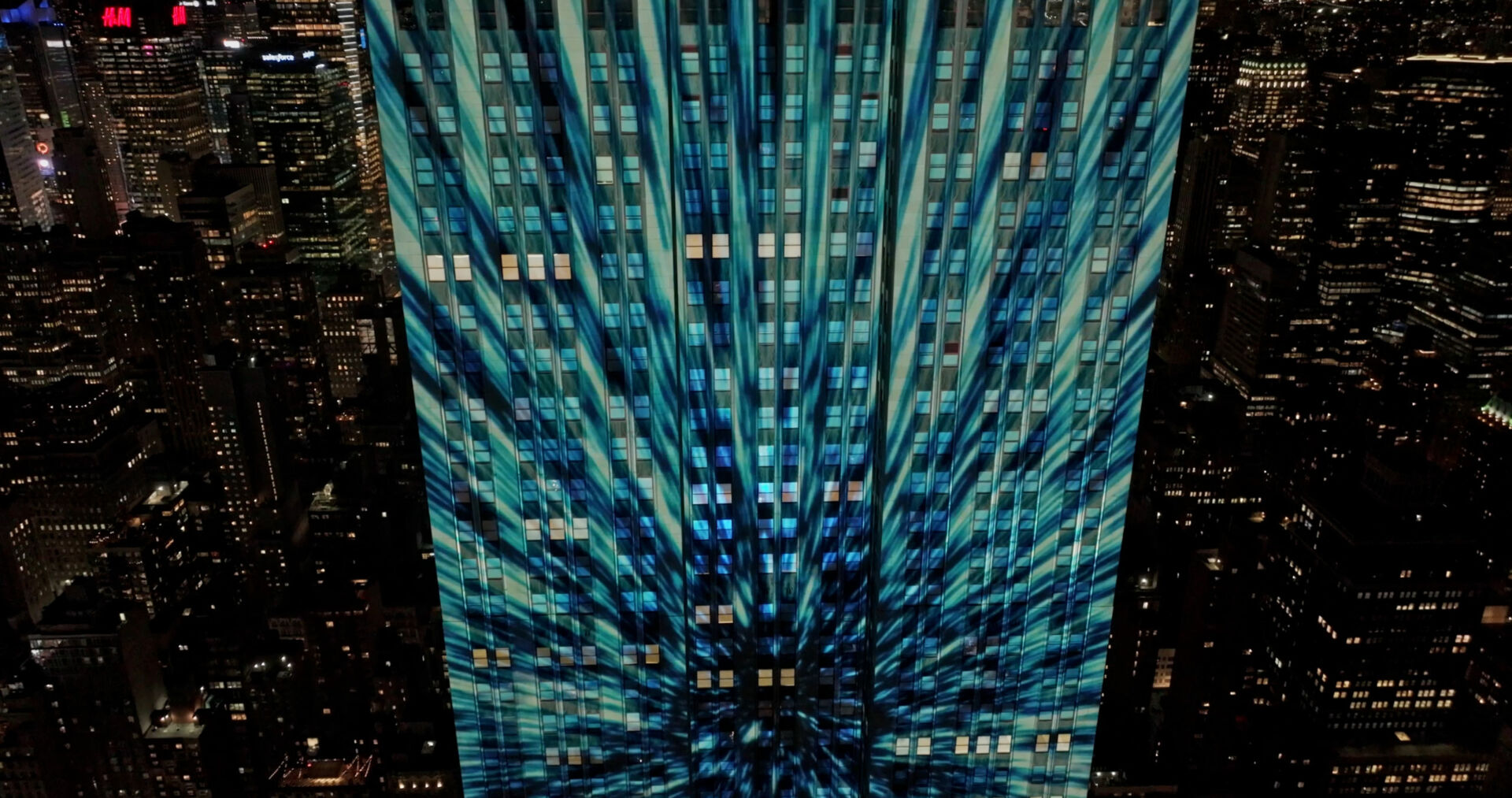 Blue light-speed starburst projected across the upper floors of the Empire State Building
