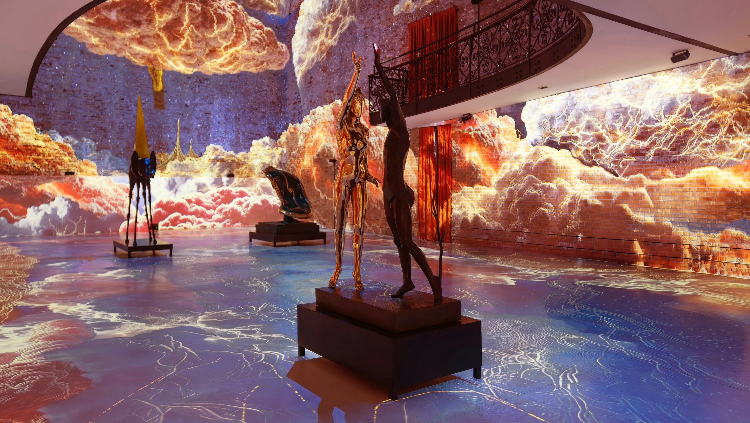 An immersive hall with surreal Dalí cloudscapes projected across walls and floor around bronze sculptures